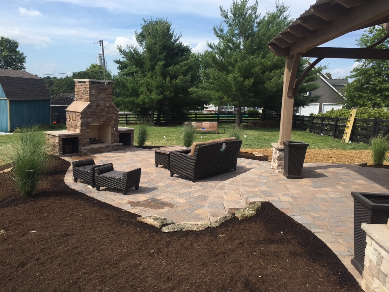 Outdoor living space with stone patio, pergola, and fireplace in Nicholasville KY